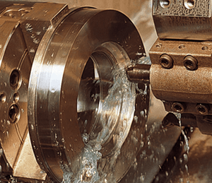 Metallbearbetning med kylvätska som sprutas över skärverktyg under bearbetning.