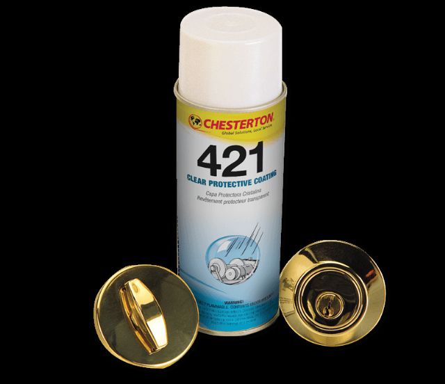 Chesterton 421 "CLEAR PROTECTIVE COATING" tillsammans med två guldaktiga metallföremål som ser ut att vara lås eller liknande beslag.