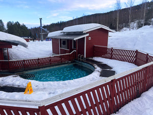 Svarta värmemattor som skapar en snöfri passage runt en utomhuspool under vintersäsong.