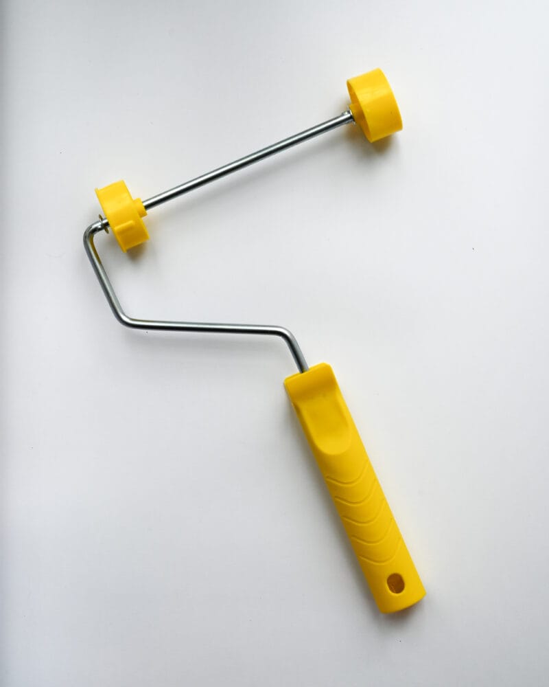 Rollerbygel 18 cm med gult ergonomiskt handtag och metallbygel i stål. Designad för strukturroller med två gula hjul. 